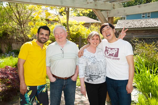 Homestay Victoria husband and wife couple in their backyard with two international male students smiling together